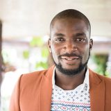 Attractive young African man looking at camera. Contented young man with facial hair and moustache facing camera, Nigeria, Africa.